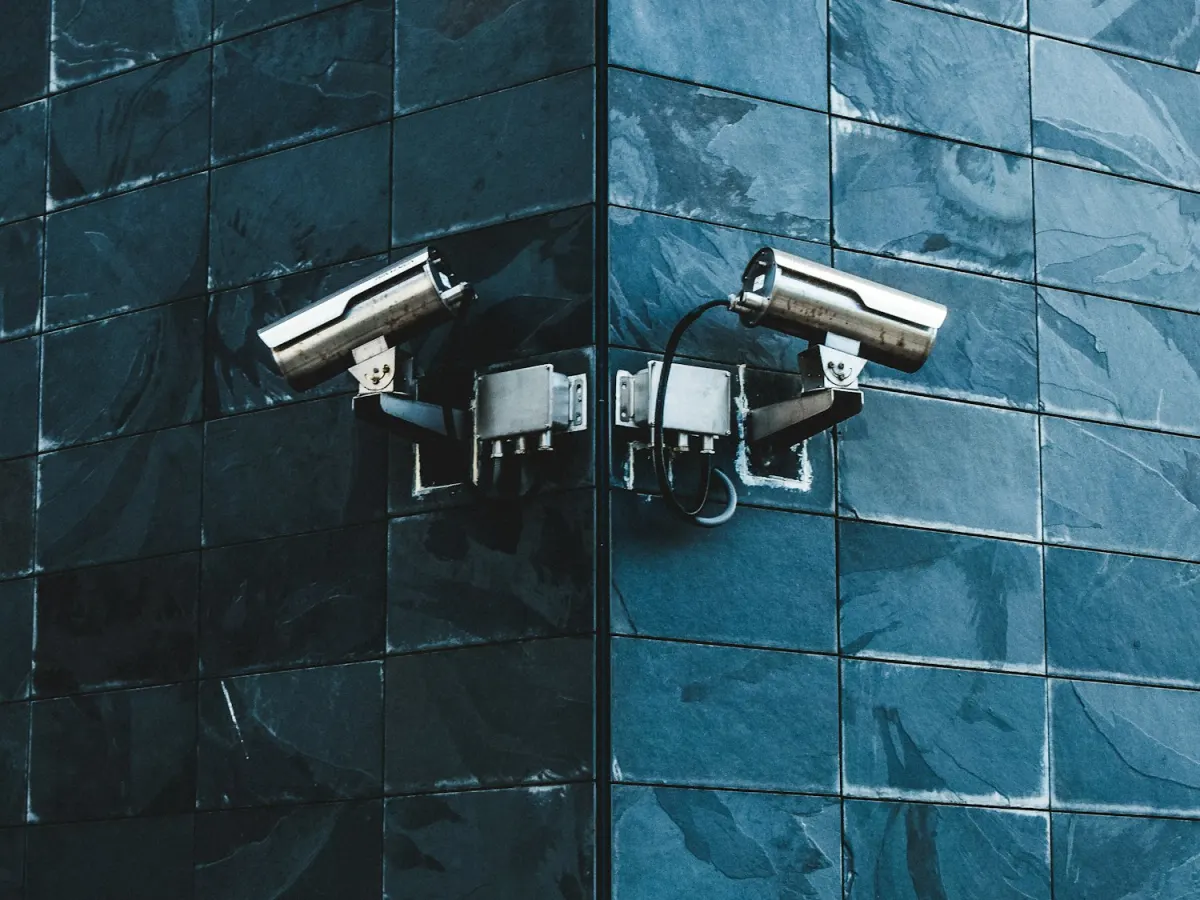 Stainless steel CCTV cameras professionally mounted on a modern slate-clad building